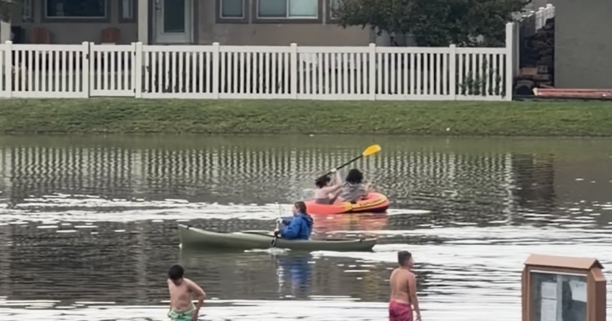 A number of folks canoe in flooded Utah streets