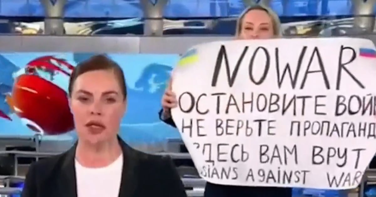 Un manifestant avec une pancarte “Pas de guerre” entre sur le plateau de télévision d’État russe