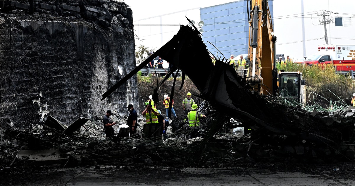 Los rescatistas sacan un cuerpo de los restos del camión en llamas debajo del paso elevado de la I-95 en Filadelfia.