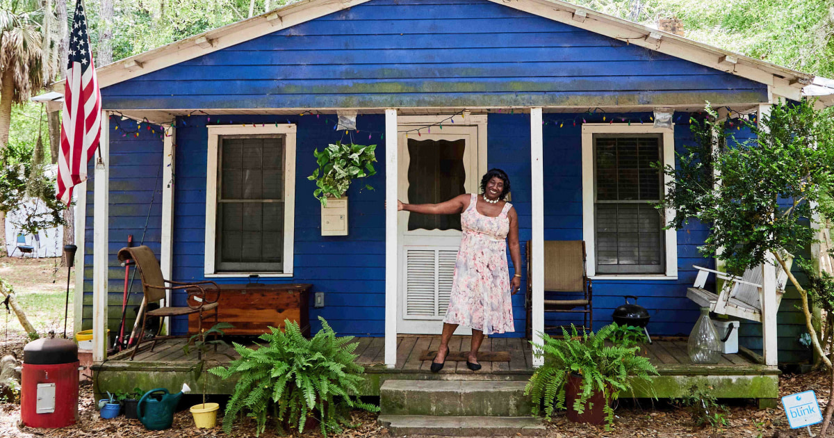 Сали Ан Робинсън гордо стои в предния двор на дома