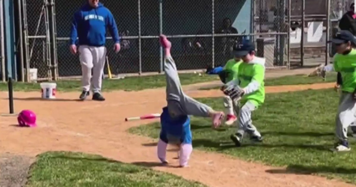 6yearold girl cartwheels her way to first base during Tball game