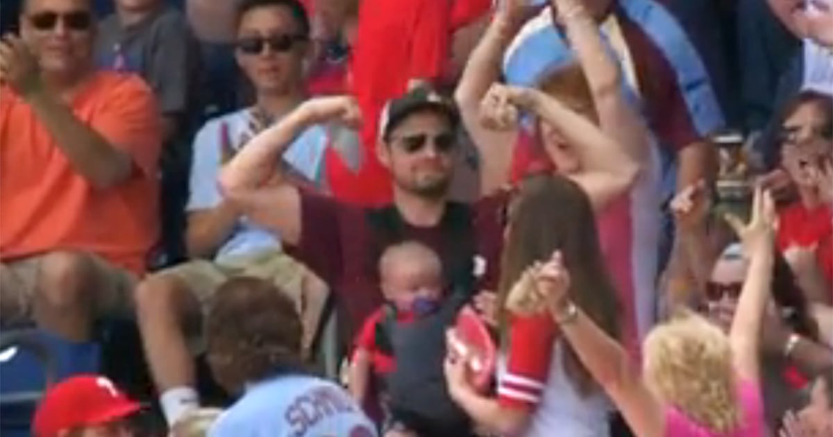 Watch Phillies fan catches foul ball — with infant son strapped to his