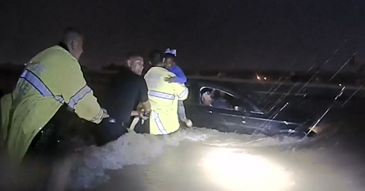 Police form human chain to save family trapped in car during Tropical ...