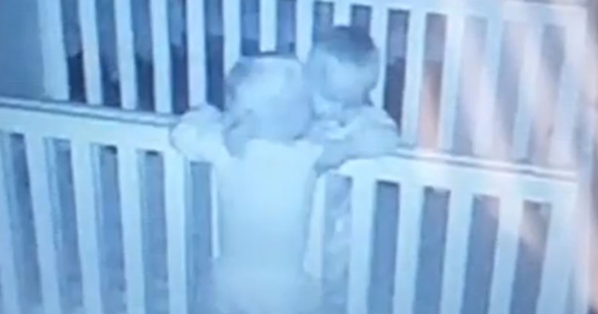 Baby monitor captures identical twins hugging in their cribs