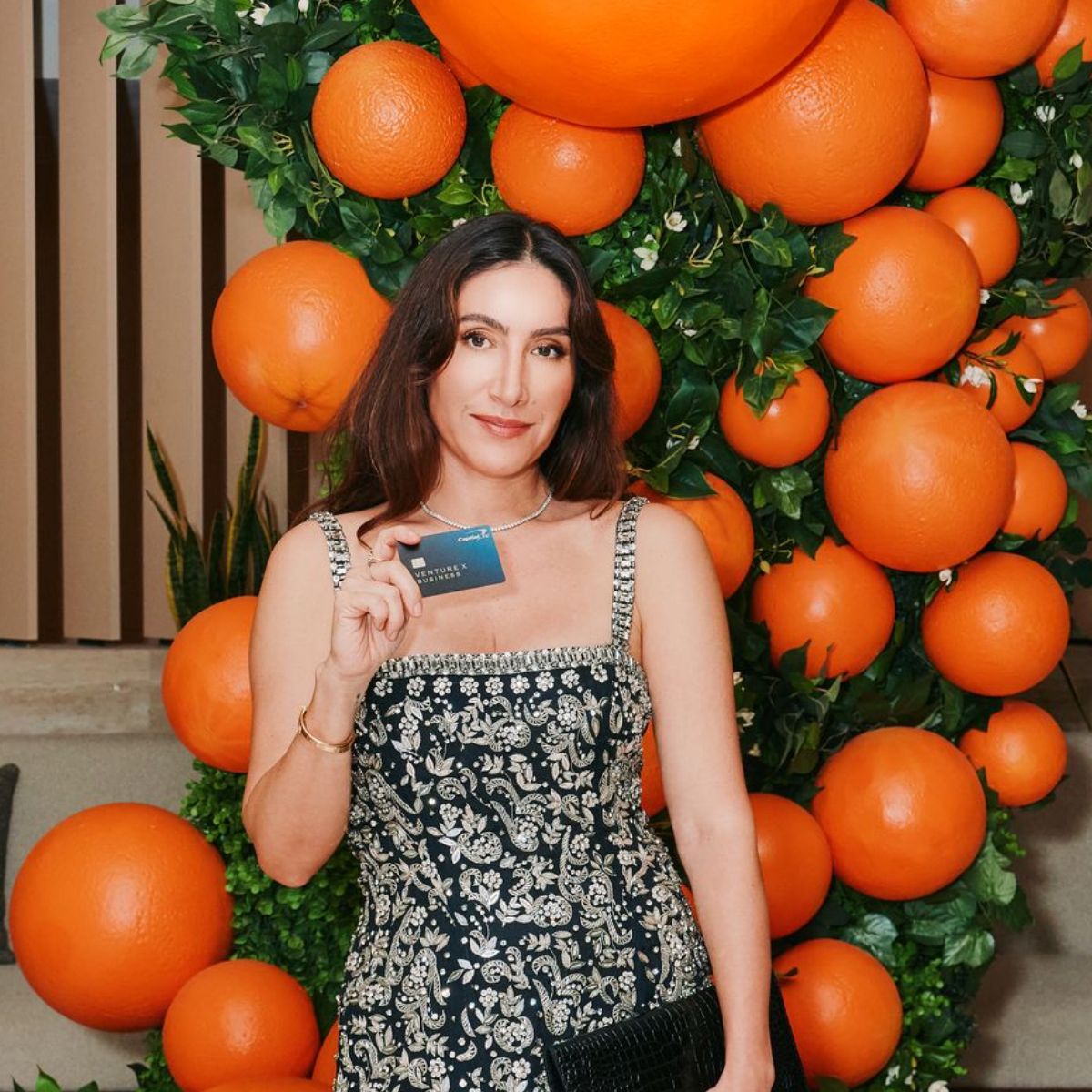 Jen Atkin styling a model’s long wavy hair in a studio setting